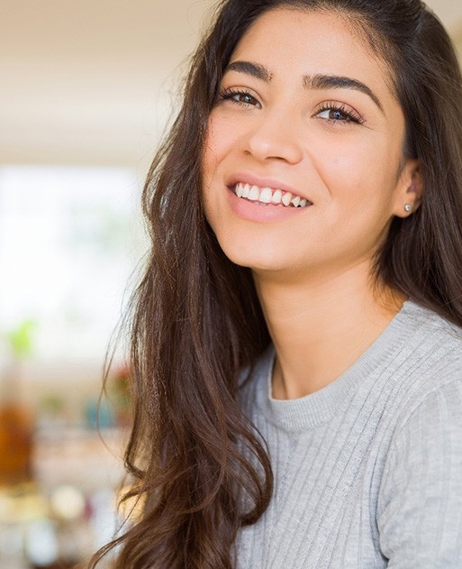 Dental assistant smiling while handing patient form